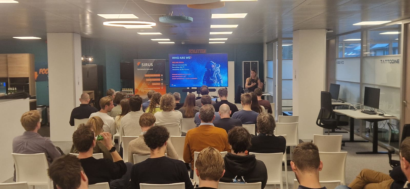 Attendees at a Fabric Belgium meetup, watching a speaker present